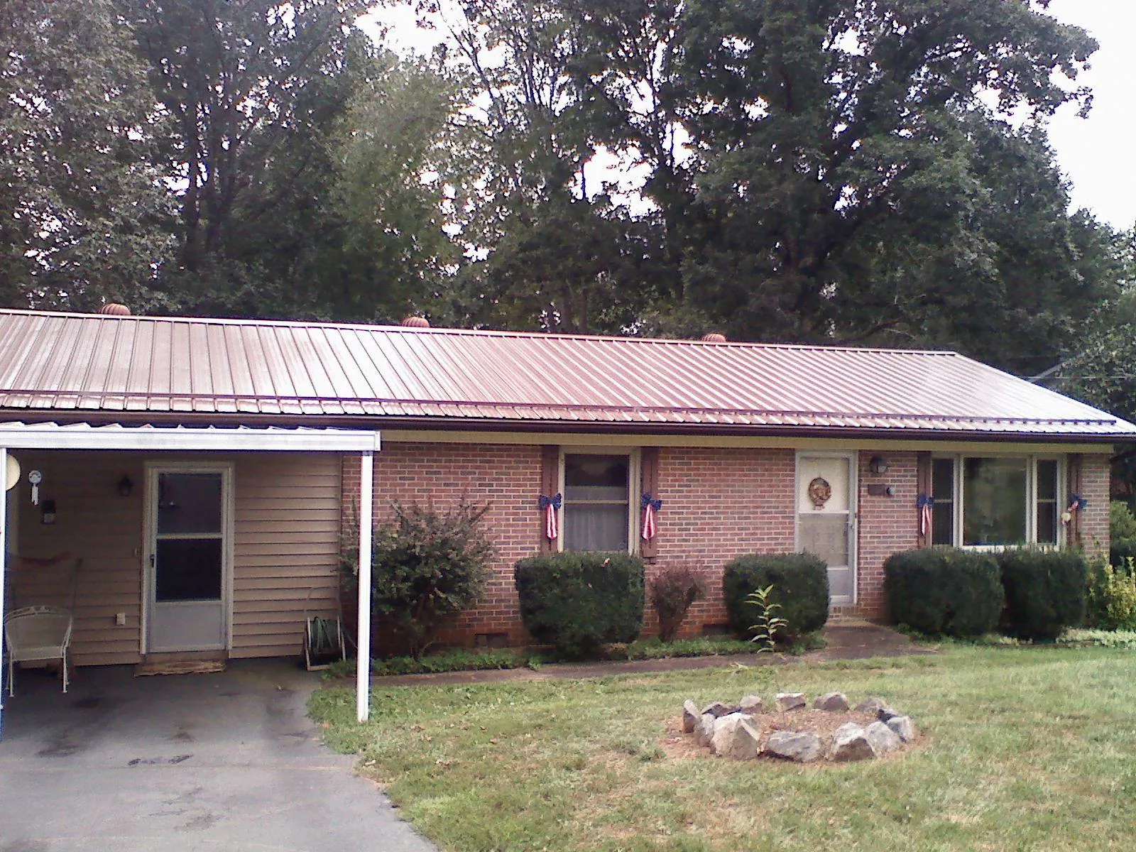 Bronze metal roof and carport on a brick ranch home — Roof Repair work by our crew in Cedarville